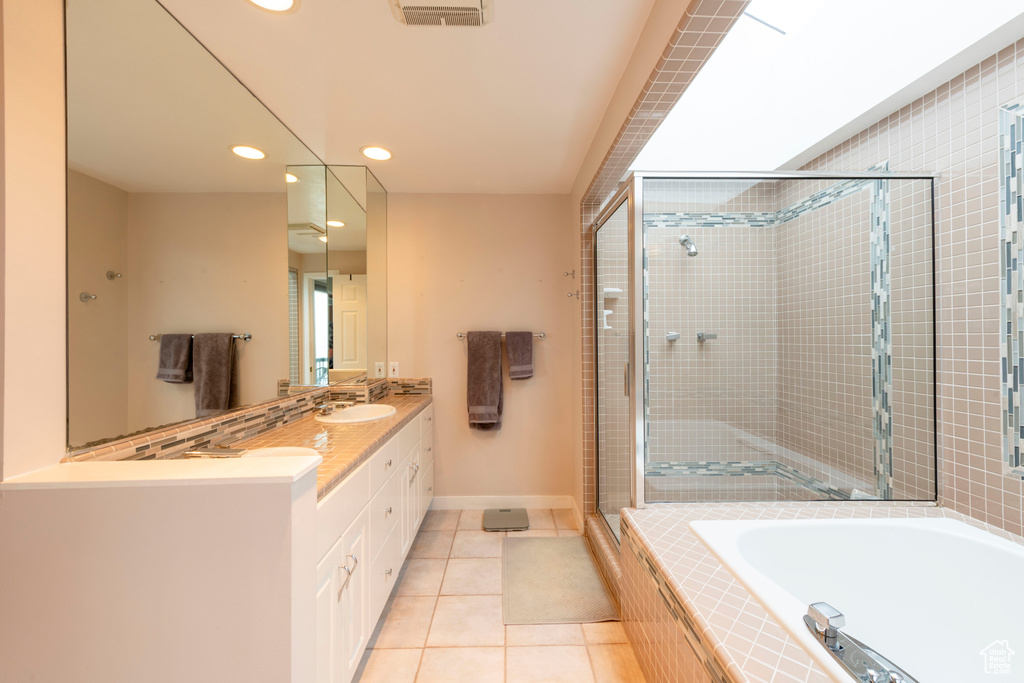 Bathroom with tile patterned floors, a stall shower, a bath, recessed lighting, and baseboards