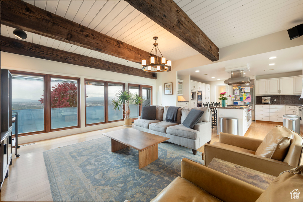 Living room with light wood-style floors, a chandelier, beam ceiling, recessed lighting, and wood ceiling