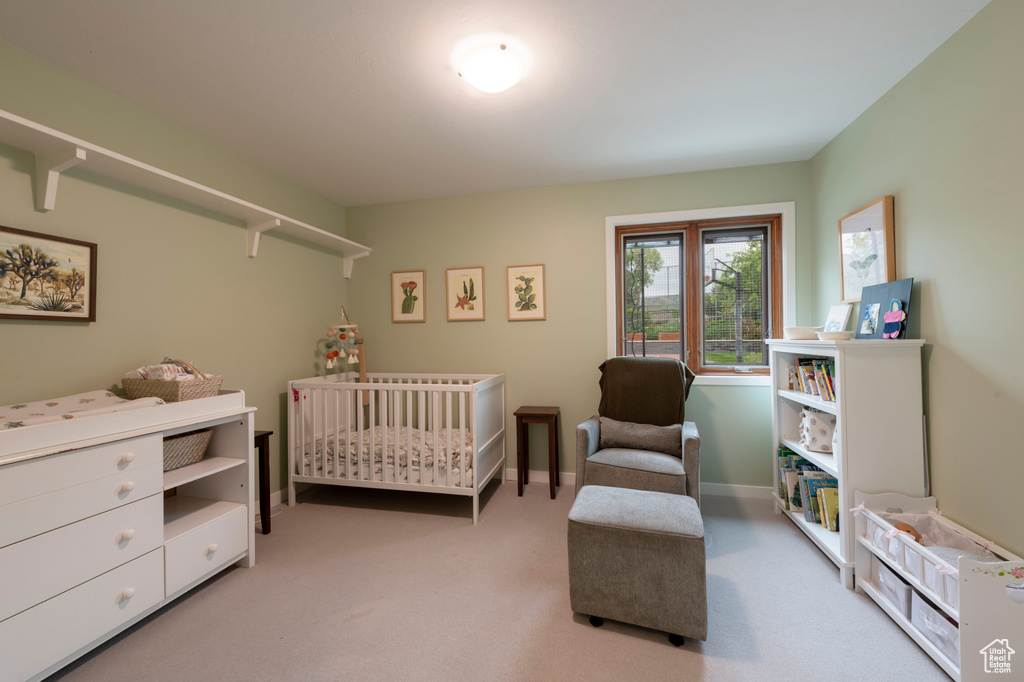 Bedroom with carpet, a crib, and baseboards