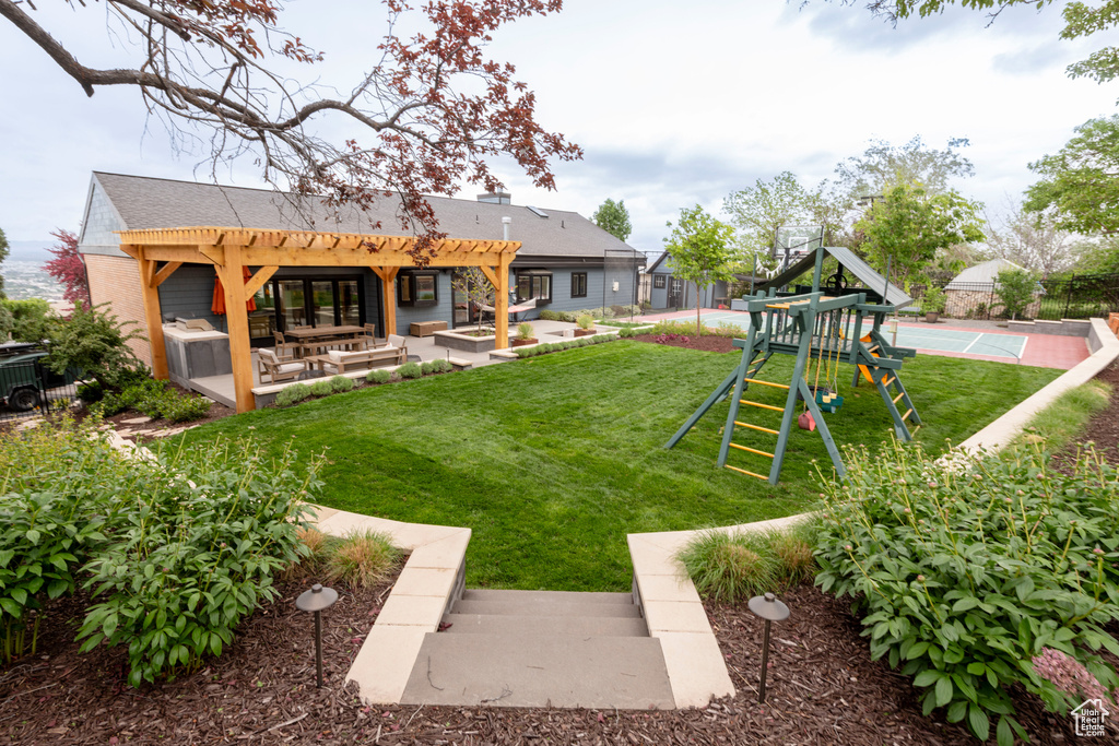 View of grassy yard featuring a pergola and shuffleboard