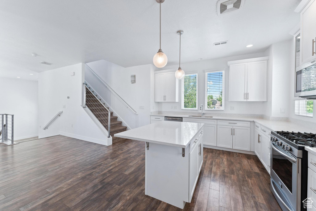 Kitchen with appliances with stainless steel finishes, dark wood-style flooring, white cabinets, and recessed lighting