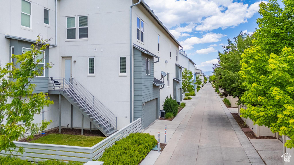 View of property exterior featuring stucco siding and stairs