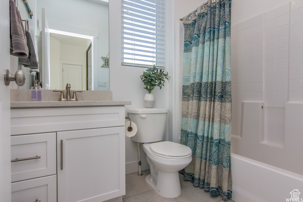 Bathroom featuring toilet, tile patterned floors, vanity, and shower / tub combo