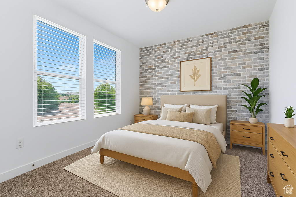 Bedroom with an accent wall and light carpet