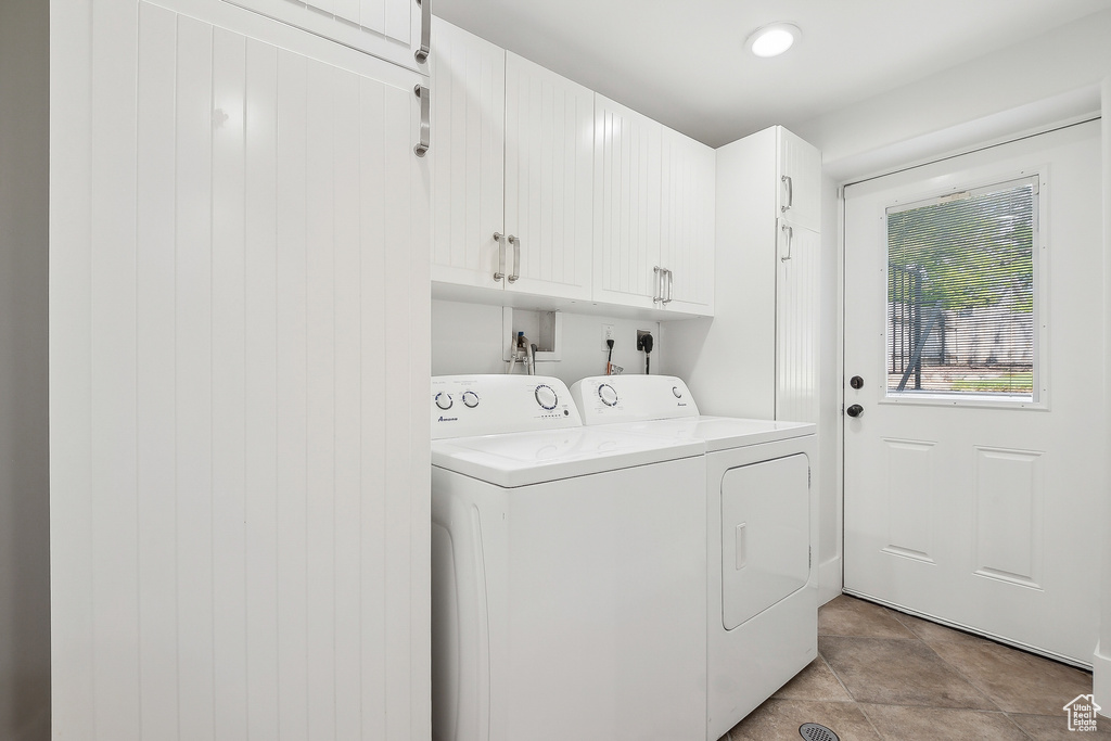 Clothes washing area featuring cabinet space and independent washer and dryer