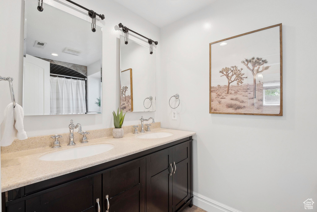 Bathroom featuring double vanity and baseboards