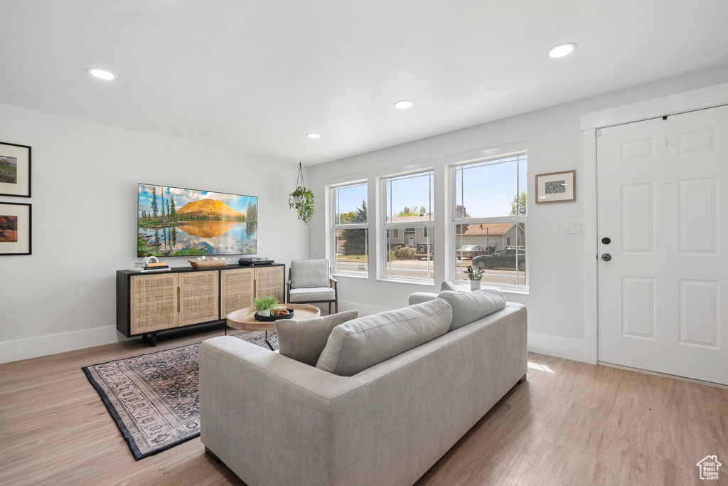 Living room with light wood-style flooring, baseboards, and recessed lighting