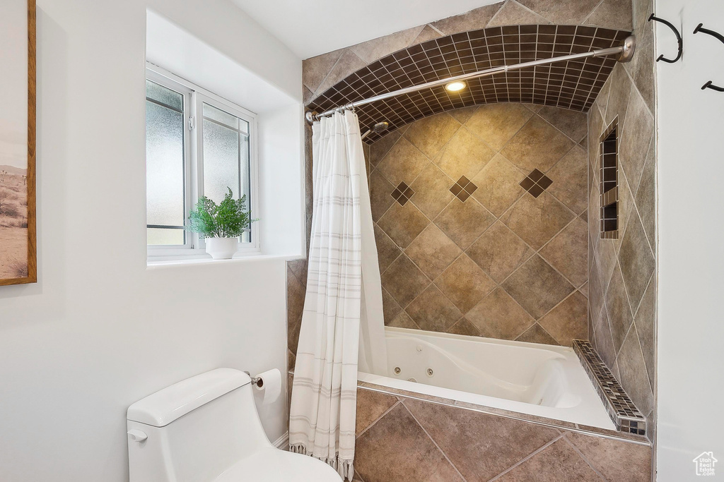 Full bath with toilet and tiled shower / bath