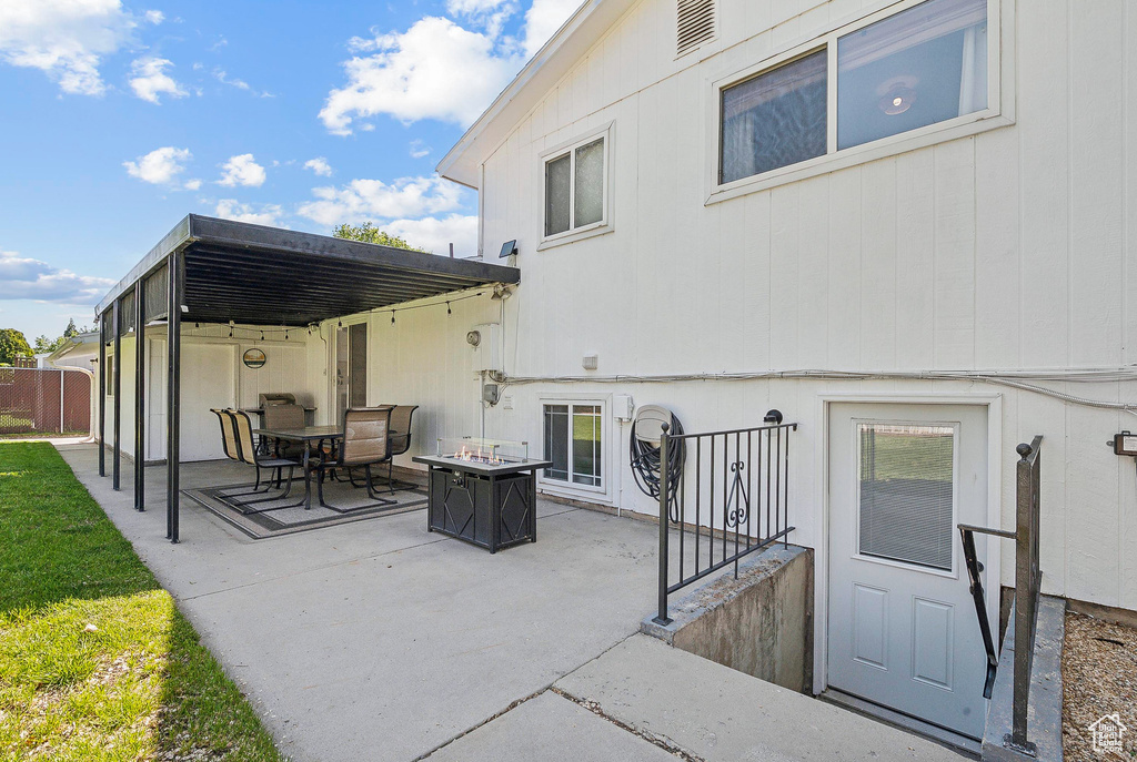 Rear view of property with a patio and a fire pit
