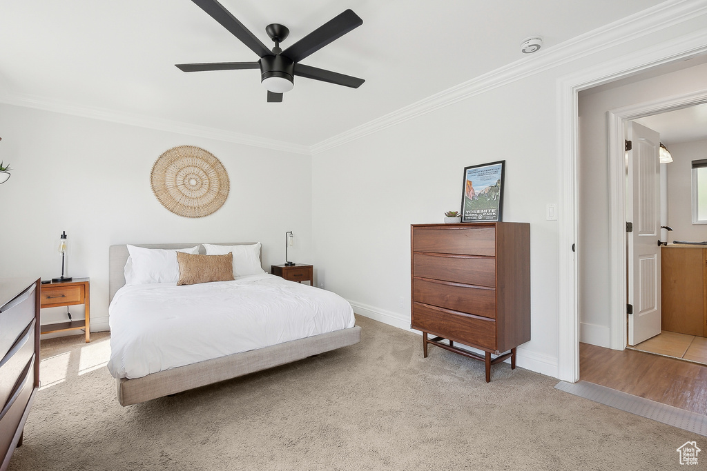 Bedroom featuring ornamental molding, carpet floors, baseboards, and a ceiling fan