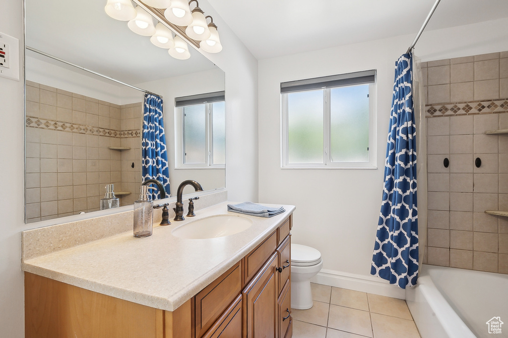 Bathroom with tile patterned floors, toilet, shower / bath combo, and vanity