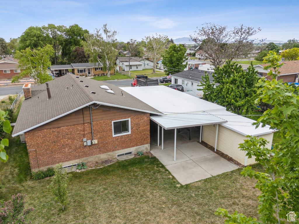 Rear view of property with brick siding, a residential view, and a yard