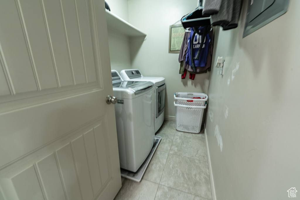 Laundry area featuring washer and clothes dryer and light tile patterned flooring