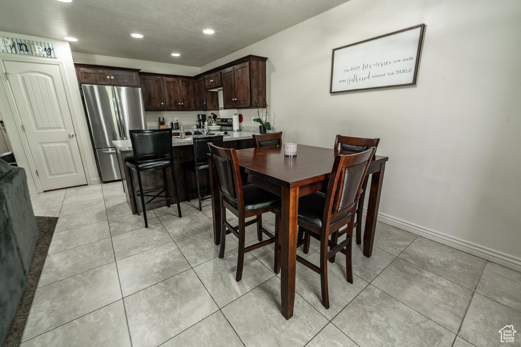 Dining area featuring recessed lighting, light tile patterned floors, and baseboards