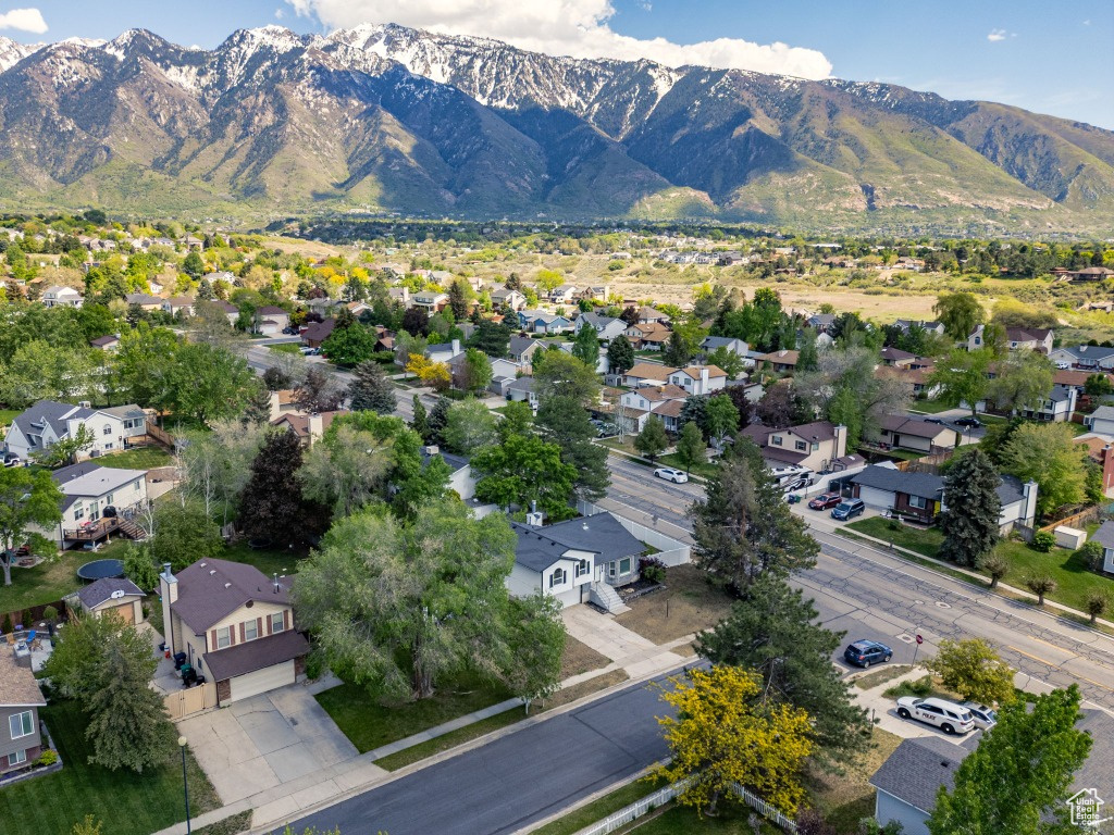 Aerial view of property and surrounding area with mountains and nearby suburban area
