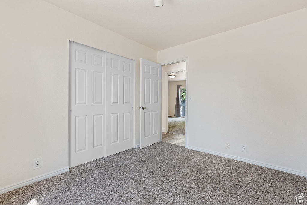 Unfurnished bedroom with carpet floors, baseboards, and a closet