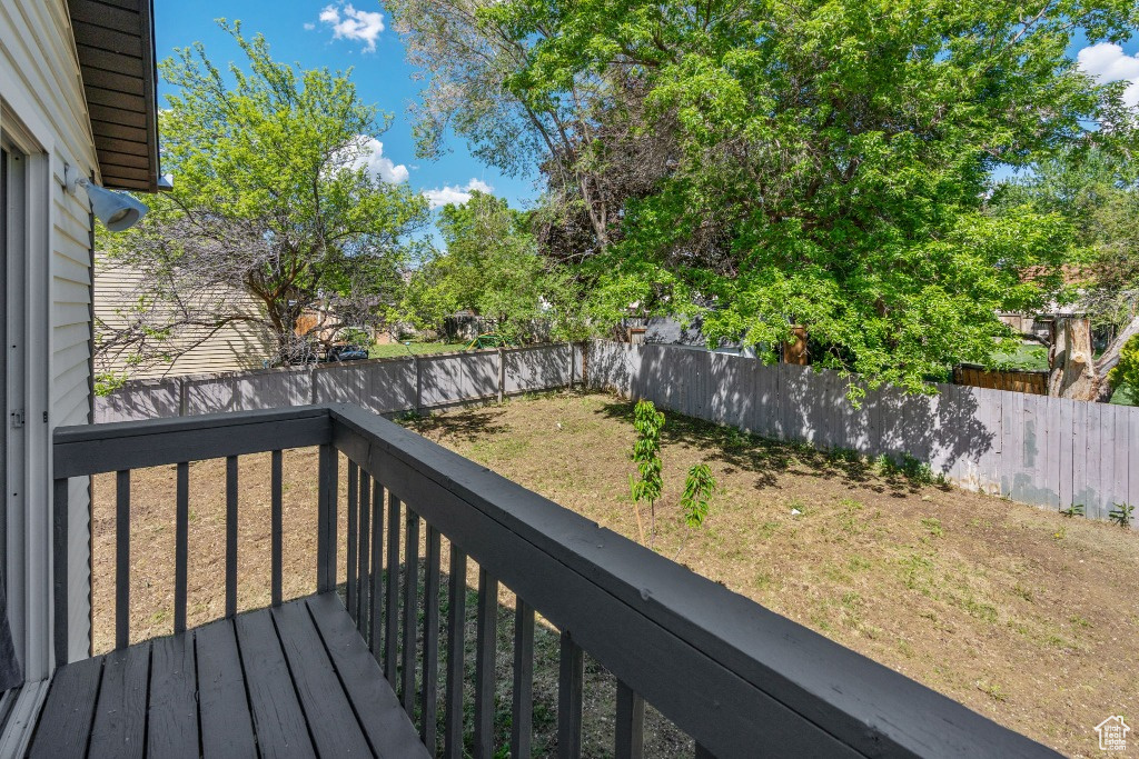 Wooden terrace with a fenced backyard