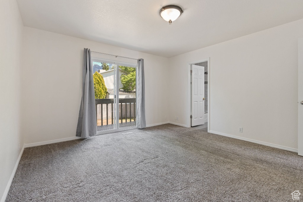 Spare room featuring carpet and baseboards