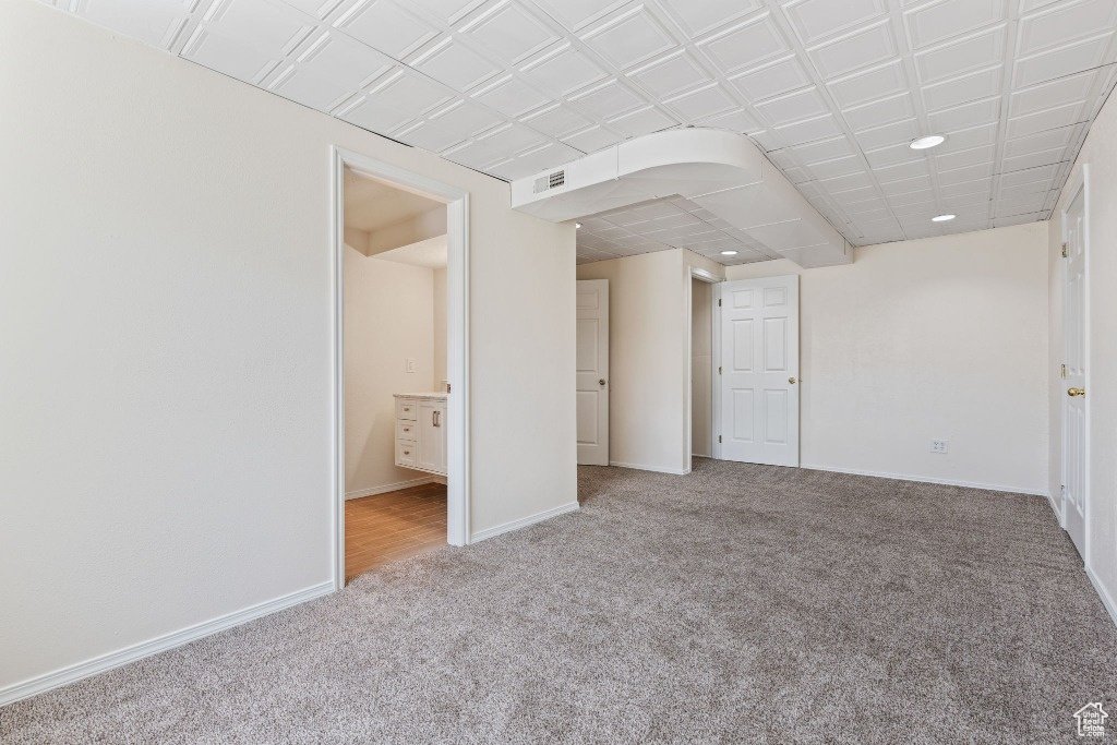 Carpeted empty room with baseboards and recessed lighting