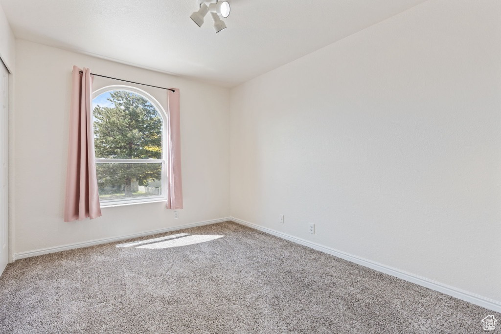 Empty room featuring carpet floors and baseboards