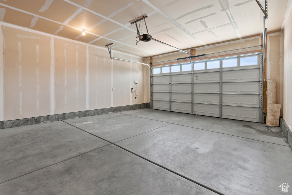 Garage with a garage door opener and baseboards