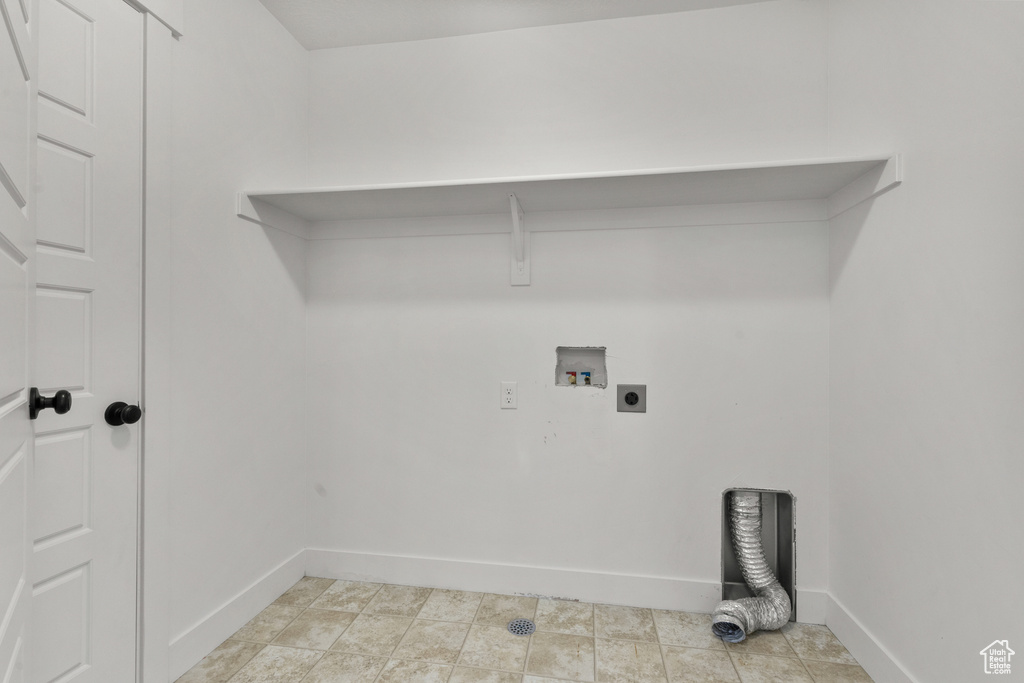 Washroom with hookup for an electric dryer, hookup for a washing machine, and baseboards
