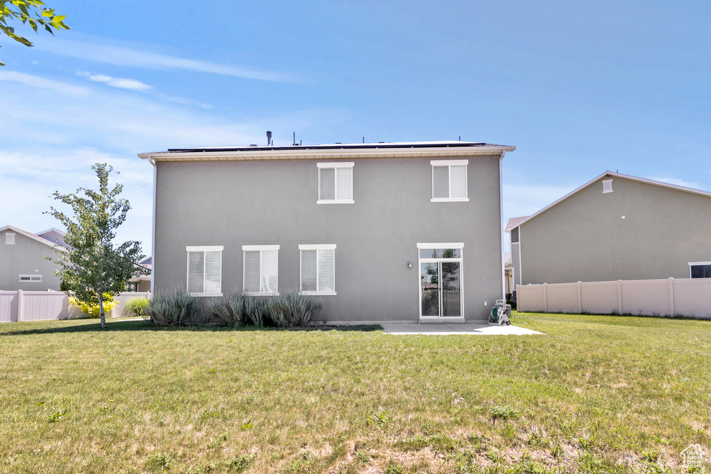 Back of house with a patio, solar panels, and stucco siding