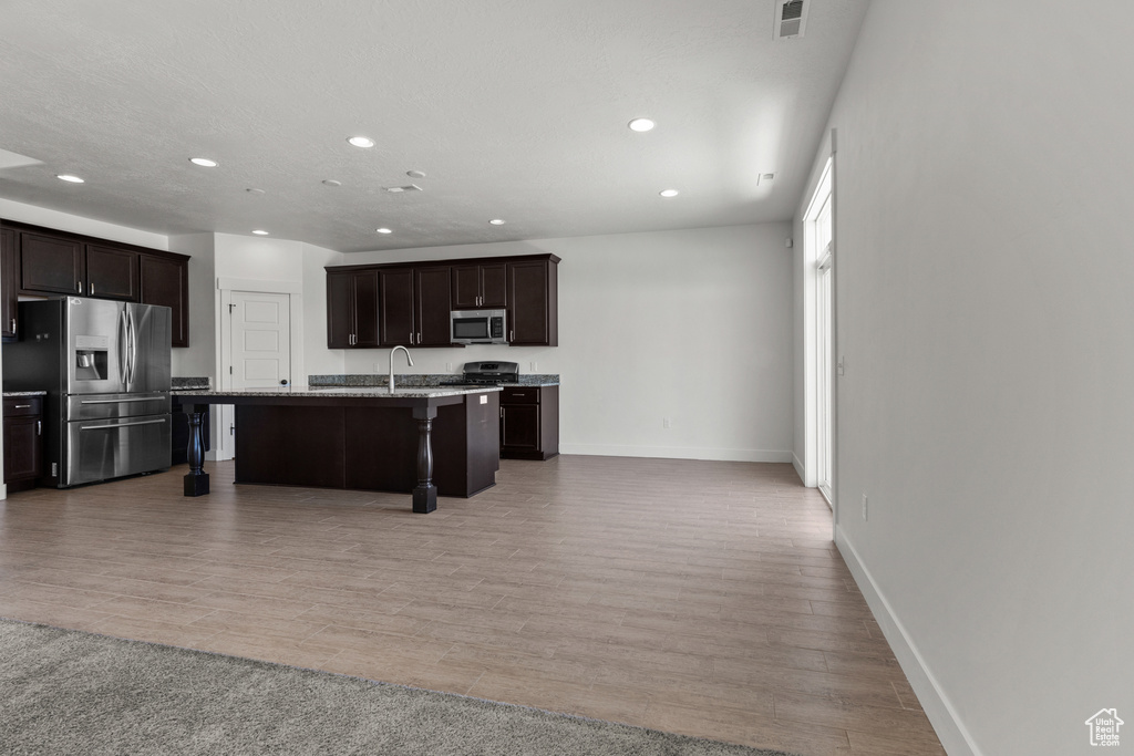 Kitchen with stainless steel appliances, recessed lighting, a sink, a kitchen bar, and a kitchen island with sink