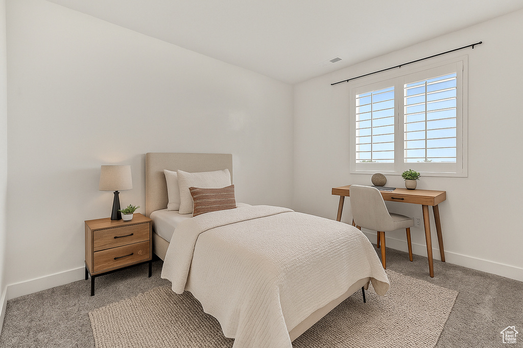 Carpeted bedroom featuring baseboards and vaulted ceiling