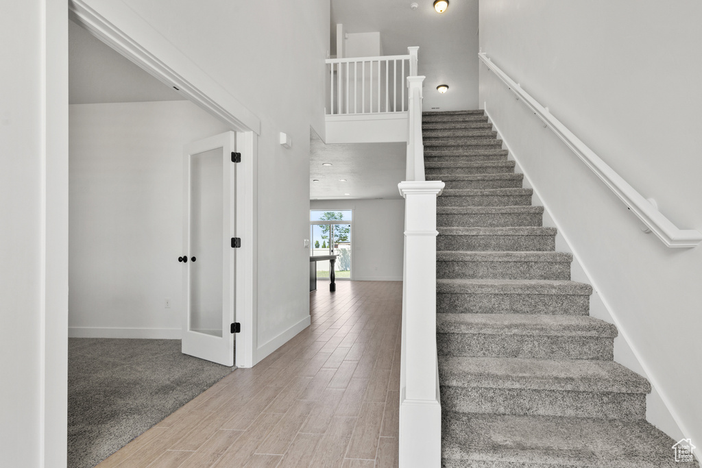 Stairway with wood finished floors and baseboards