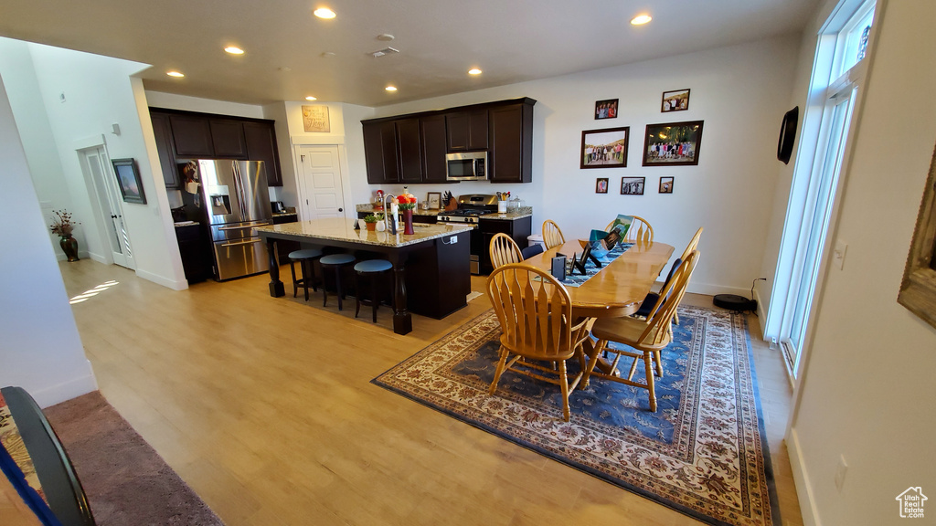 Dining space with recessed lighting, light wood finished floors, and baseboards