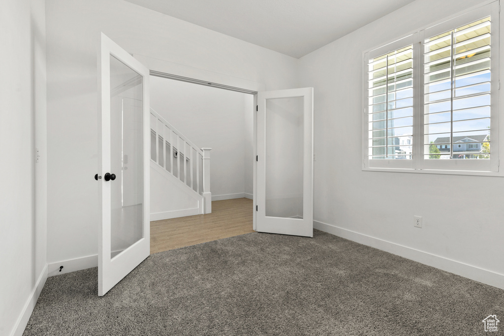 Unfurnished bedroom featuring carpet, french doors, and baseboards