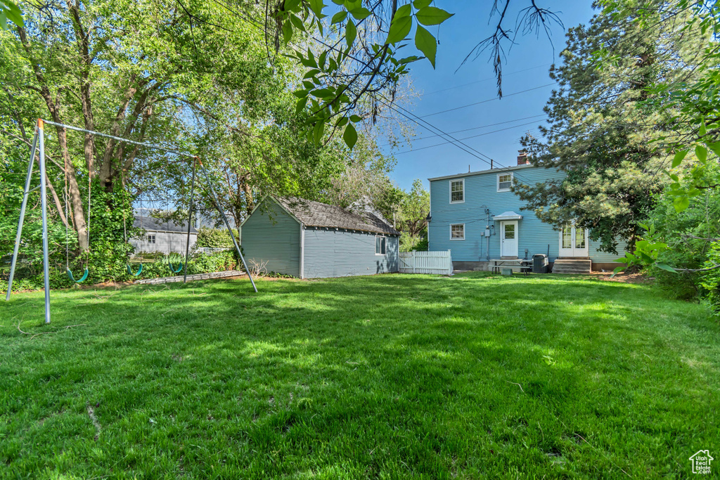 View of yard featuring an outdoor structure, entry steps, and a storage unit