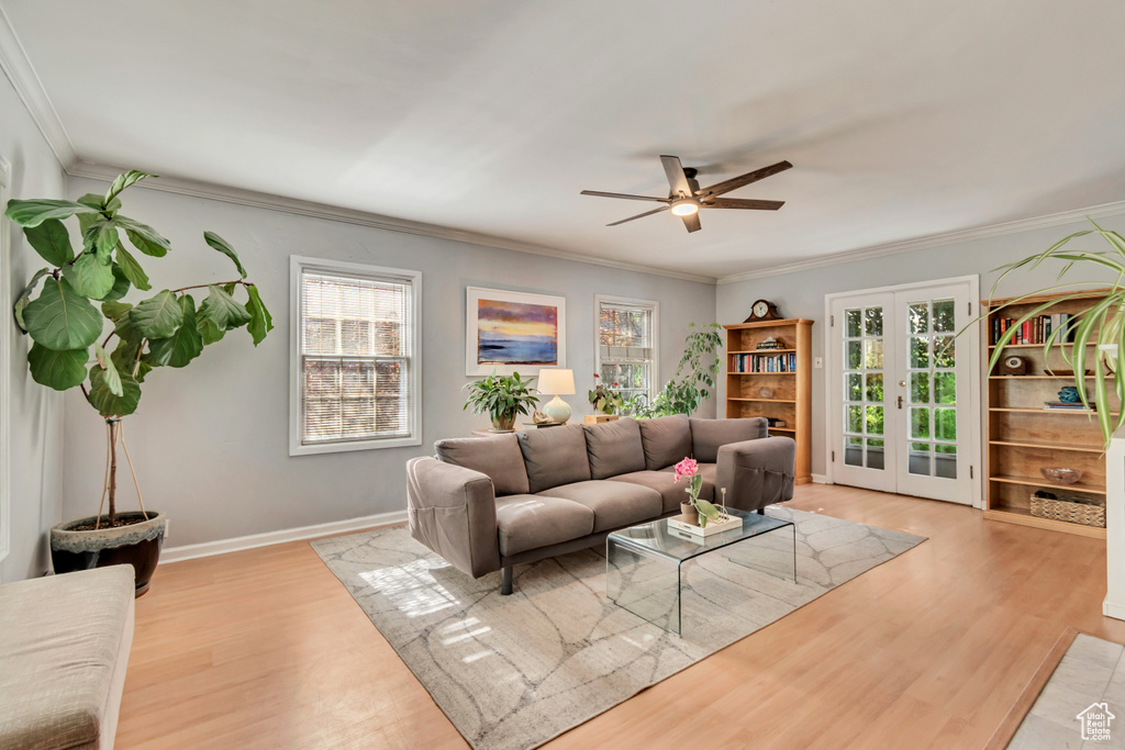 Living room featuring wood finished floors, ornamental molding, a ceiling fan, french doors, and baseboards