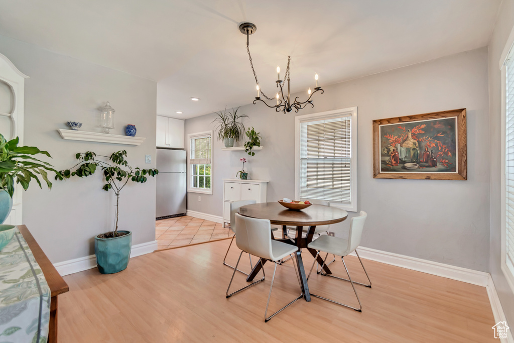 Dining room with a chandelier, light wood-style floors, baseboards, and recessed lighting