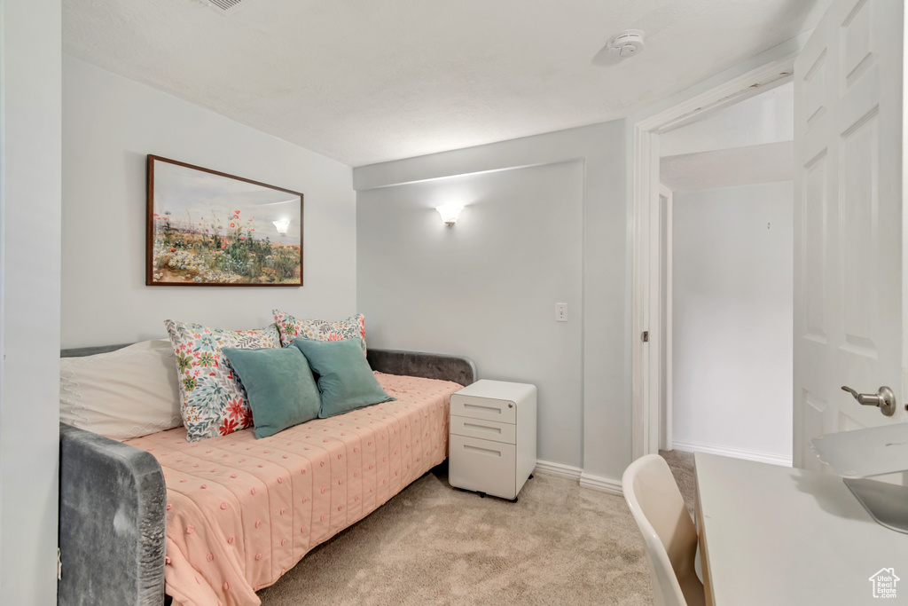 Bedroom with light carpet and baseboards