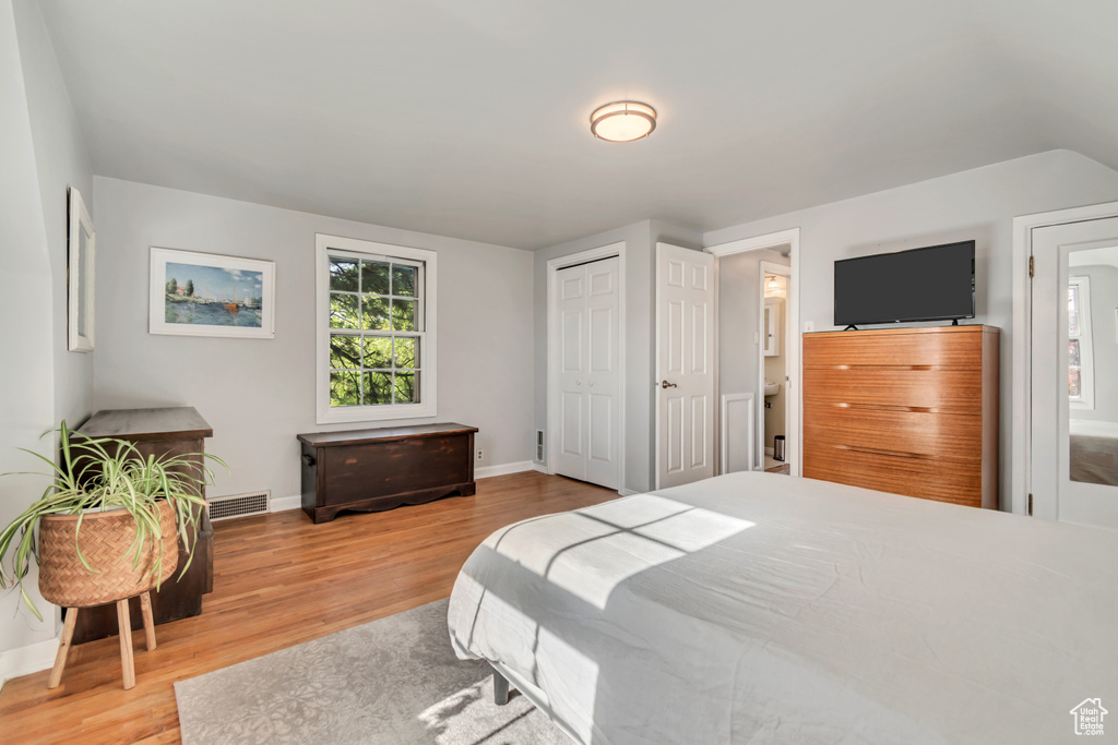 Bedroom featuring wood finished floors, baseboards, and a closet