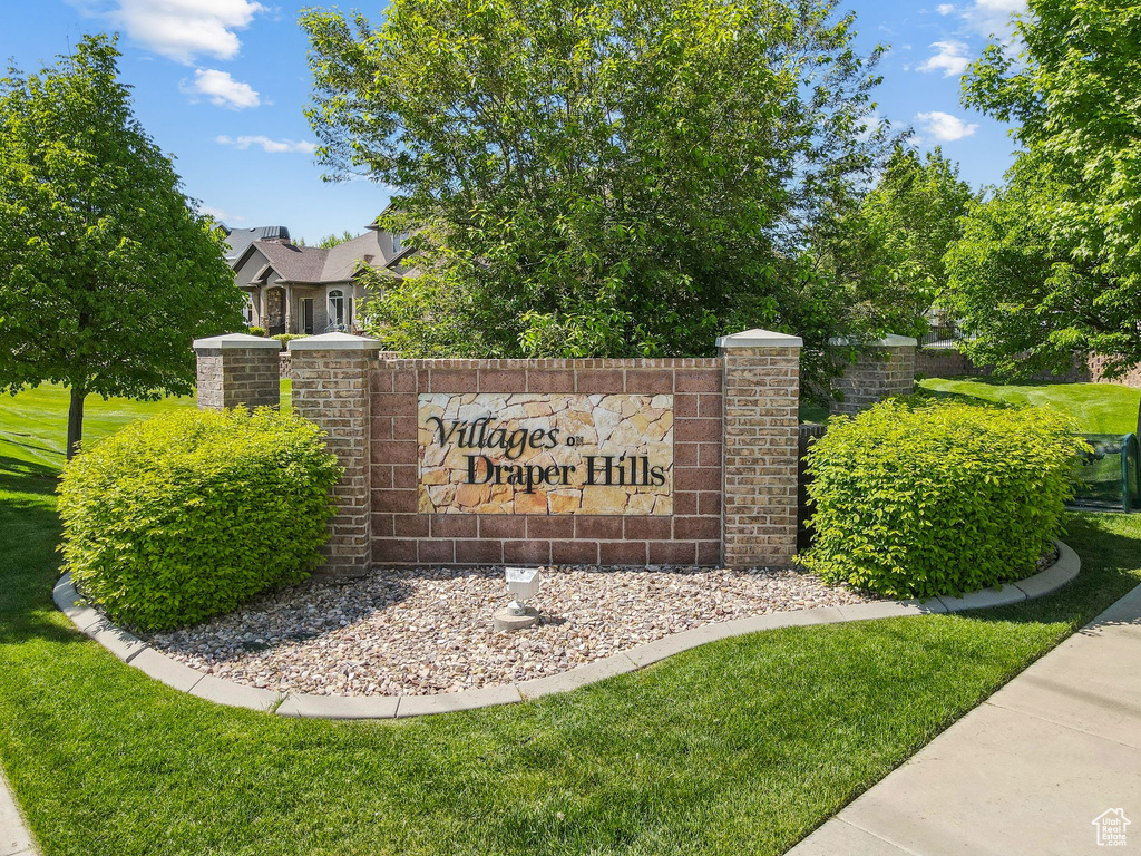 Community / neighborhood sign featuring a lawn