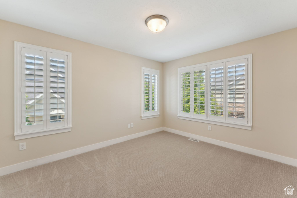 Carpeted spare room with baseboards