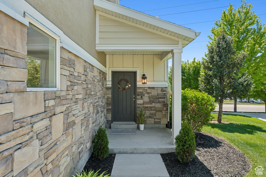 Doorway to property with stone siding and board and batten siding