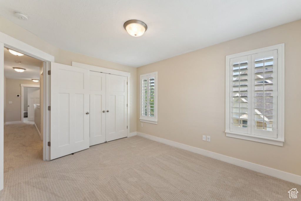 Unfurnished bedroom with carpet, baseboards, and a closet