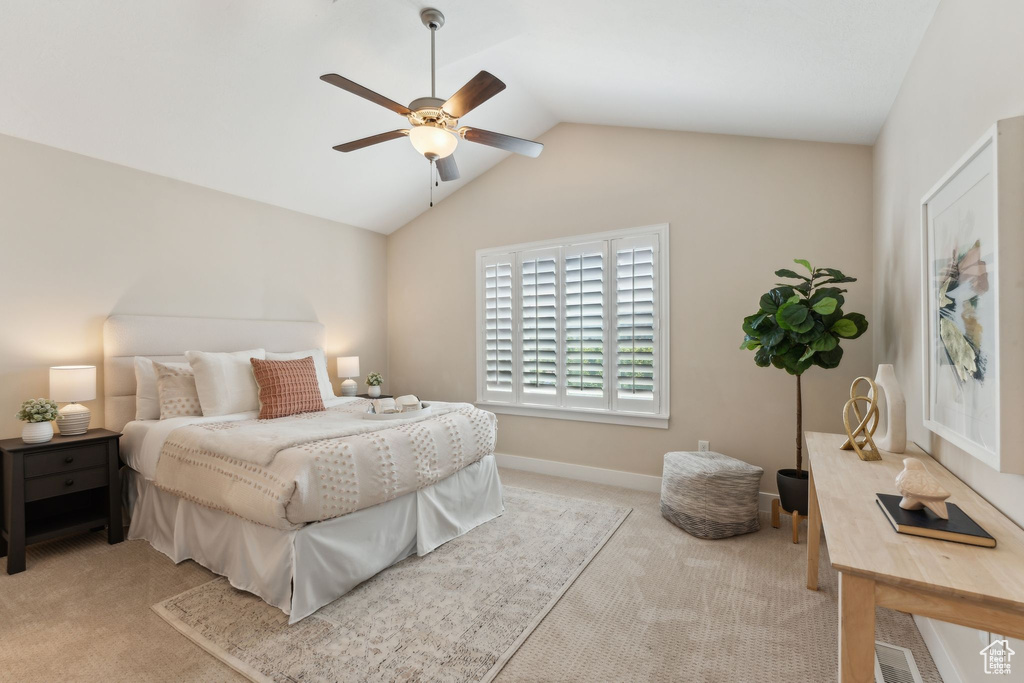 Carpeted bedroom with lofted ceiling, ceiling fan, and baseboards