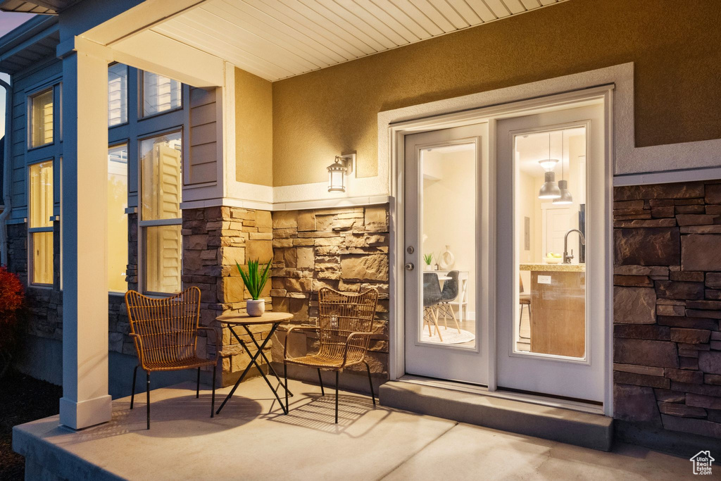 Doorway to property with stone siding and stucco siding