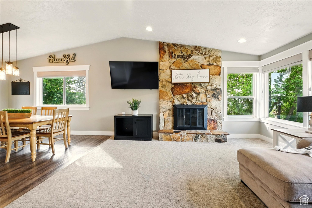 Living room featuring vaulted ceiling, baseboards, plenty of natural light, and wood finished floors