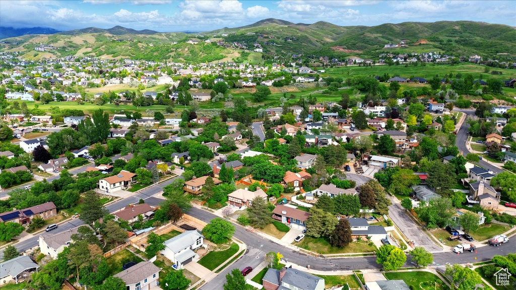 Aerial view of property's location with a mountain backdrop and nearby suburban area