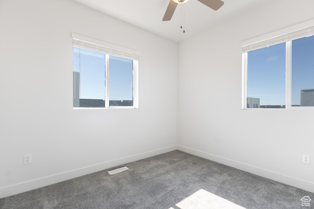 Unfurnished room featuring carpet flooring, a ceiling fan, and baseboards