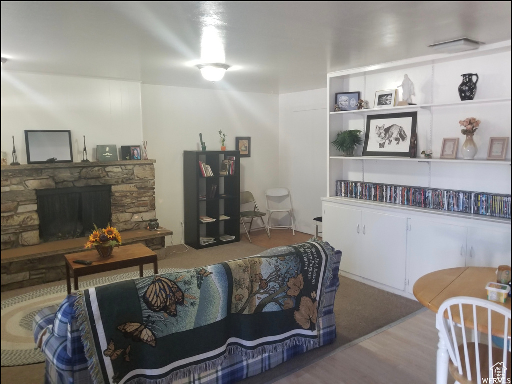 Living room featuring wood finished floors and a stone fireplace