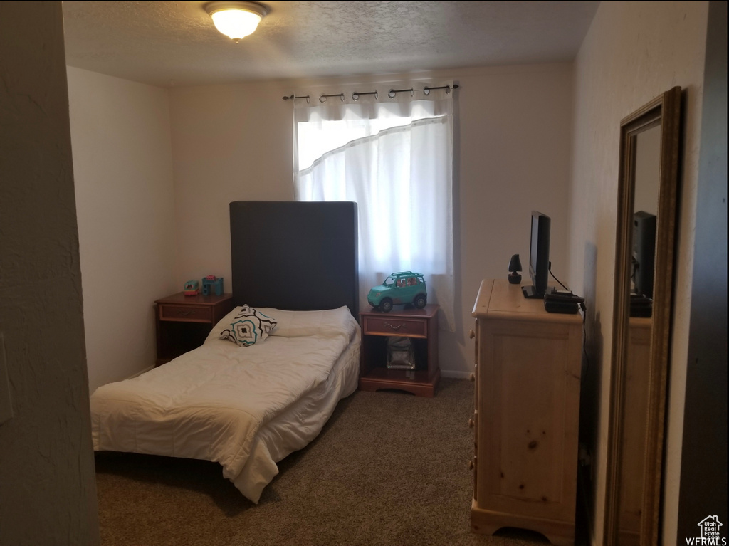Bedroom with carpet and a textured ceiling