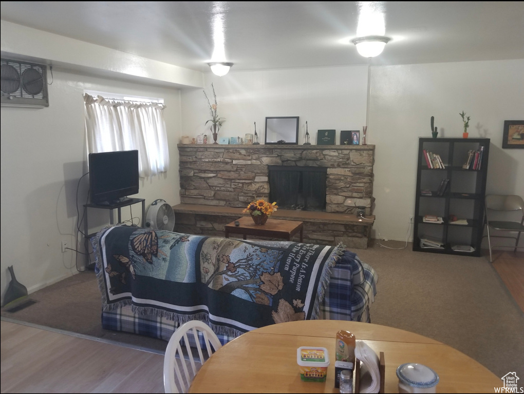Living room with a stone fireplace and wood finished floors