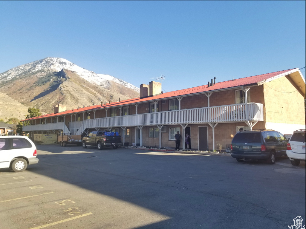 View of building exterior featuring uncovered parking and a mountain view